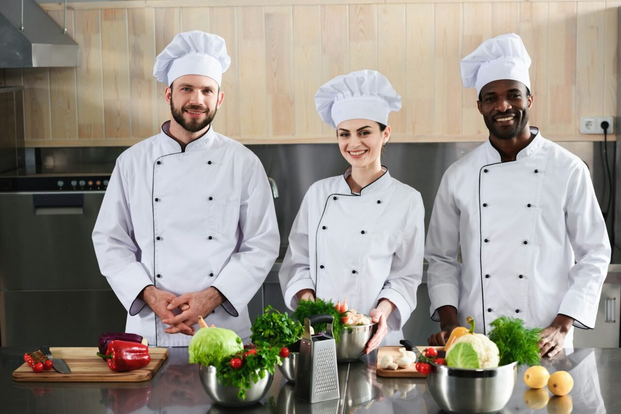 multiracial-chefs-team-smiling-by-modern-kitchen-counter.jpg